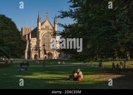 Winchester Cathedral UK, view on a summer evening of people relaxing in the grounds of Winchester Cathedral, Hampshire, England, UK Stock Photo