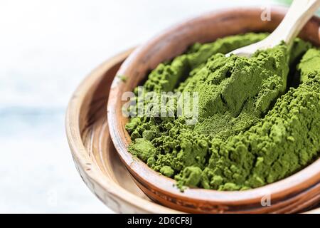 Green powder chlorella, spirulina on gray concrete background. Concept dieting, detox, healthy superfood, which contains protein. Stock Photo