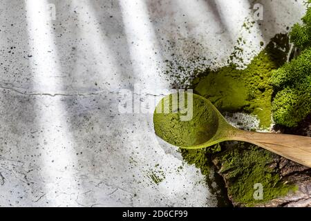 Green powder chlorella, spirulina on gray concrete background. Concept dieting, detox, healthy superfood, which contains protein. Stock Photo