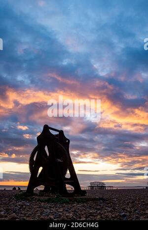 Brighton seafront with old winch and West Pier at sunset dusk Sussex England UK Stock Photo