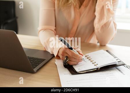 Woman making notes in diary Stock Photo