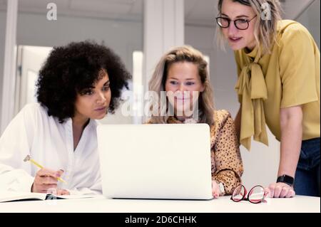 Women using laptop in boardroom Stock Photo