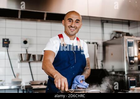 Smiling chef working in kitchen Stock Photo