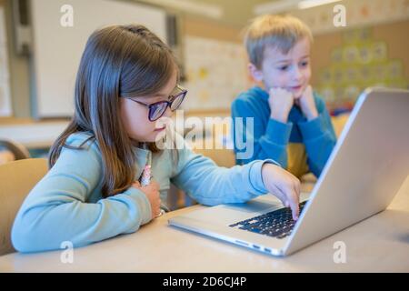 Girl using laptop in classroom Stock Photo
