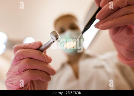 Dentist holding drill and mirror Stock Photo