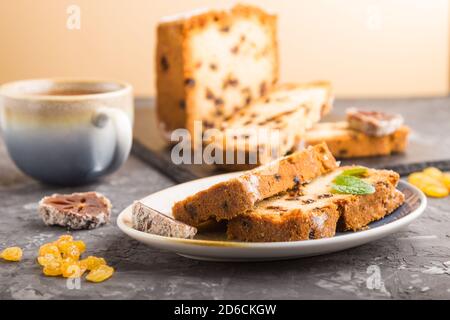 Homemade cake with raisins, dried persimmon and a cup of hot chocolate on a black concrete background. Side view, close up, copy space, selective focu Stock Photo