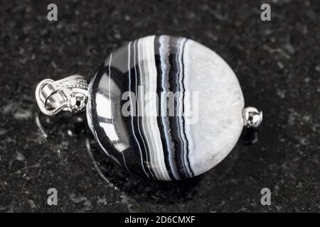 pendant from striped Agate gemstone on black granite background Stock Photo