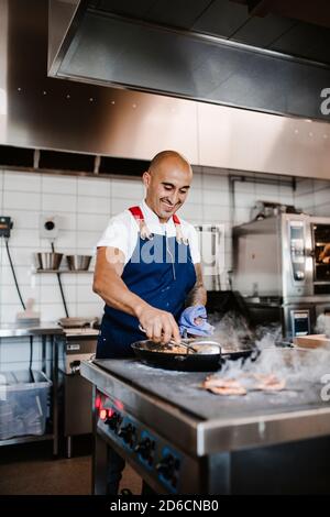 Smiling chef working in kitchen Stock Photo