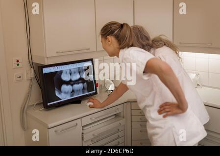 Dentist looking at x-ray on screen Stock Photo