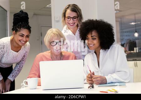 Women using laptop in boardroom Stock Photo