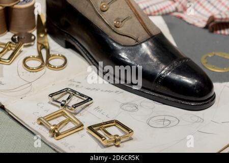 Cobblers' Table With Gold Buckles, Various Accessories,  Leather Shoes and Sketch Drawings Stock Photo