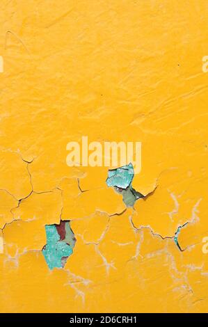 Texture background of bright yellow peeling paint with blue streaks on the old concrete surface Stock Photo