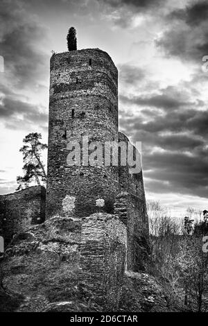 Beautiful medieval Czech caszle Gutstejn located on the rock above the river in the Western Bohemia, shot at sunset in monochrome. HDR Stock Photo