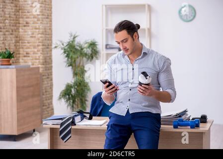 Handsome male employee doing exercises in the office Stock Photo