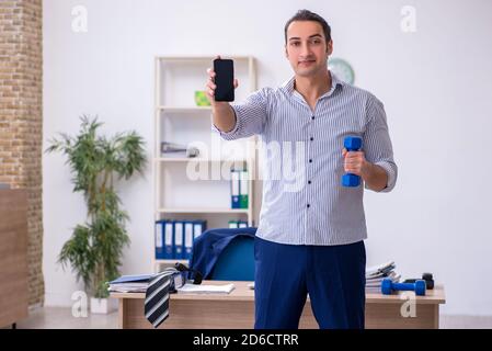 Handsome male employee doing exercises in the office Stock Photo