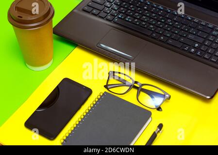 Office stuff with pen, paper notebook,smartphone,laptop eyeglasses coffe cup.Top view.Working colorful desk table Stock Photo
