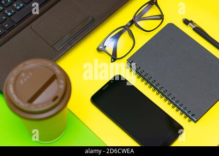 Office stuff with pen, paper notebook,smartphone,laptop eyeglasses coffe cup.Top view.Working colorful desk table Stock Photo