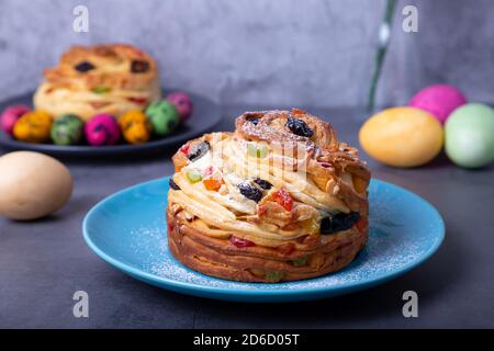 Craffin (Cruffin) with raisins, nuts and candied fruits. Easter Bread Kulich and painted eggs. Easter Holiday. Close-up. Stock Photo
