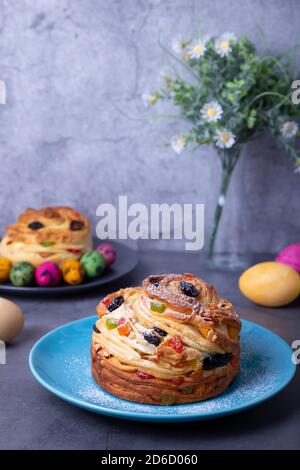 Craffin (Cruffin) with raisins, nuts and candied fruits. Easter Bread Kulich and painted eggs. Easter Holiday. Close-up. Stock Photo