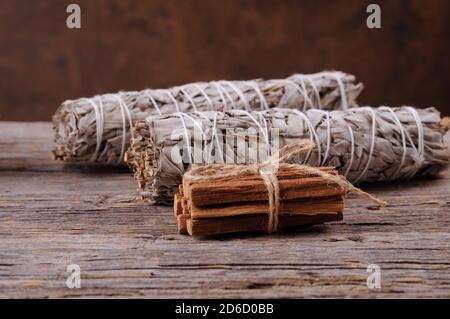 Dried white sage smudge bandle and palo santo sticks  on old  wooden background. Energy clearing and healing.Horizontal orientation with space for tex Stock Photo