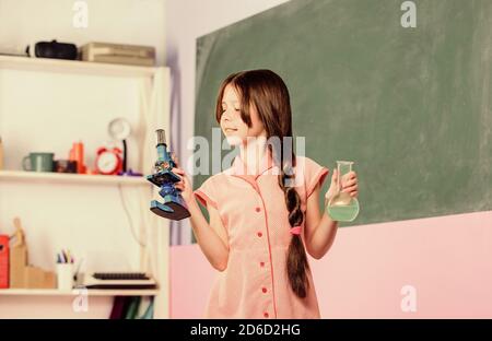 Life under microscope. back to school. biology education. science lesson with microscope. school laboratory. Modern technology. small girl with lab flask. girl study chemistry with testing tube. Stock Photo