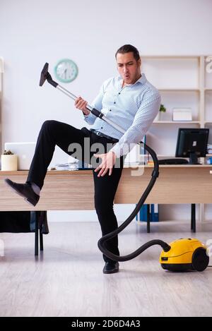 Young employee businessman cleaning office during pandemic Stock Photo