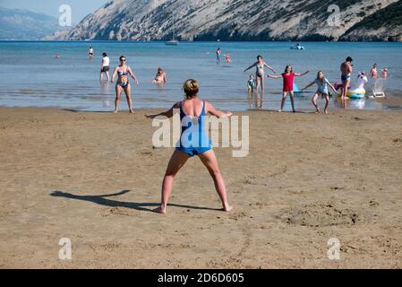24.06.2020, San Marino, Rab, Primorje-Gorski kotar, Croatia - Aerobic exercise for tourists at Paradise Beach. 00A200624D042CAROEX.JPG [MODEL RELEASE: Stock Photo