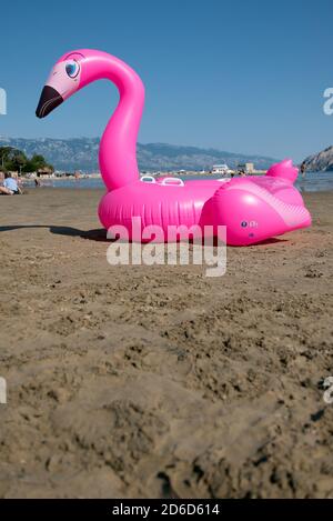 26.06.2020, San Marino, Rab, Primorje-Gorski kotar, Croatia - pink inflatable rubber swan at Paradise Beach. 00A200626D199CAROEX.JPG [MODEL RELEASE: N Stock Photo