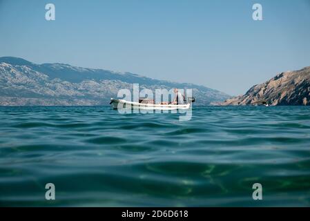 26.06.2020, San Marino, Rab, Primorje-Gorski kotar, Croatia - Fisherman is driving towards the harbor at Paradise Beach. 00A200626D140CAROEX.JPG [MODE Stock Photo