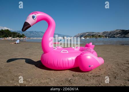 26.06.2020, San Marino, Rab, Primorje-Gorski kotar, Croatia - pink rubber inflatable swan at Paradise Beach. 00A200626D195CAROEX.JPG [MODEL RELEASE: N Stock Photo