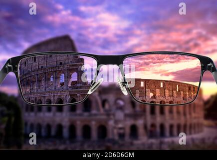 Focused image of Colosseum in Rome at sunset against purple cloudy sky in glasses frame. Better vision concept. Stock Photo