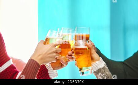 Happy friends doing celebratory toast in winter Christmas holidays - Young people drinking beer in xmas time Stock Photo
