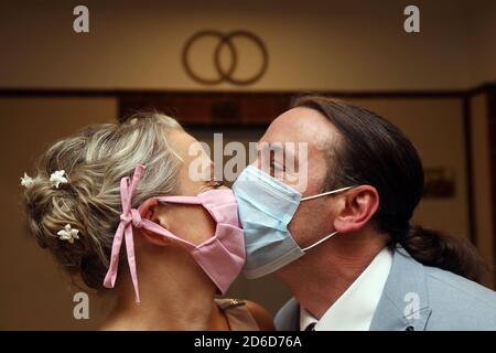 14.05.2020, Berlin, , Germany - Bridal couple kissing in times of corona pandemic with mouth-nose protection. 00S200514D352CAROEX.JPG [MODEL RELEASE: Stock Photo