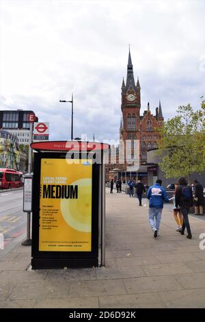 Local Covid Alert Level Medium sign on a bus stop in Kings Cross, London. The UK government has introduced a new three-tier system with restrictions increasing depending on the levels in each area. Stock Photo