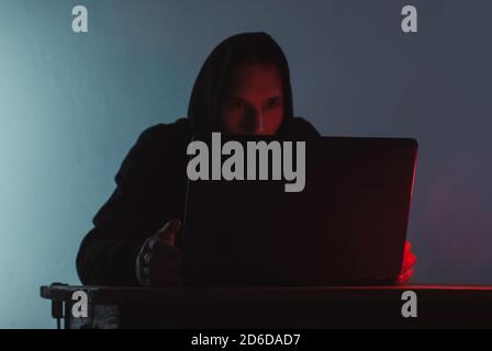 the hooded man is working on a laptop, Stock Photo