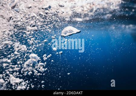 Underwater bubbles texture in blue ocean. Air bubbles in tropical sea with sun light. Stock Photo