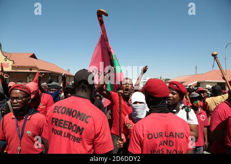 Members of the Economic Freedom Fighters (EFF) and Julius Malema supporters chant slogans outside the magistrates court during the protest.A tense standoff between white farmers and Black activists gripped the South African town of Senekal, as two men accused of killing a white farm manager were to appear in court. More than 100 police patrolled the area in front of the courthouse in the Free State province and used barbed wire to separate the rival groups. Stock Photo