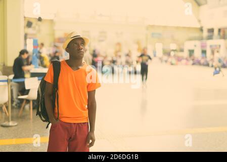 Young black African tourist man thinking inside the railway station in Bangkok Thailand Stock Photo