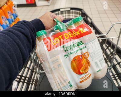 Puilboreau, France - October 14, 2020:Pack of Tropicana Orange juice deposited in the supermarket cart by a man Stock Photo