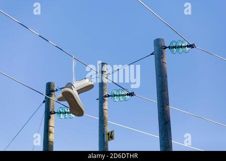 a pair of sneakers hang on a power line Stock Photo