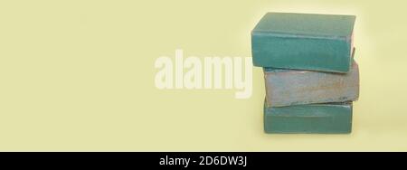 A stack of three old books lies on a plain green background. Banner Stock Photo