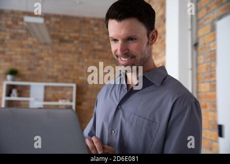 Man smiling while using laptop Stock Photo