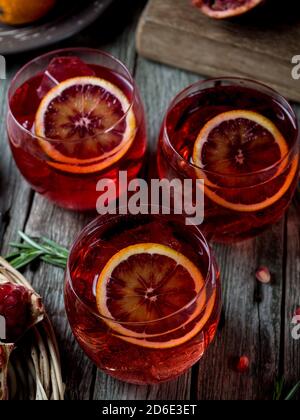 Blood orange and pomegranate cocktails on a grunge wooden table Stock Photo