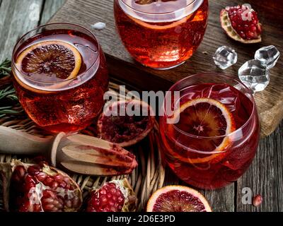 Blood orange and pomegranate cocktails on a grunge wooden table Stock Photo