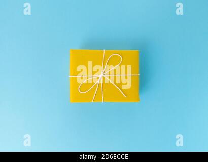 Yellow gift box on a blue background. Stock Photo