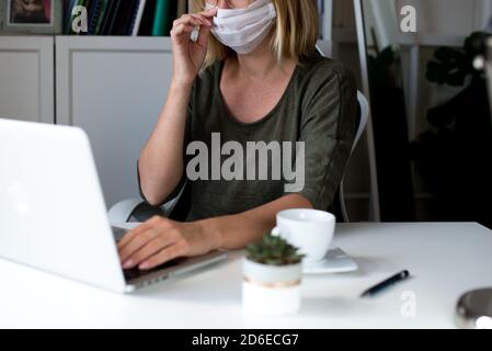 Woman working on her laptop with blank copy space screen. Mock up laptop with womans hands.Back view of business women hands using laptop.Home office Stock Photo