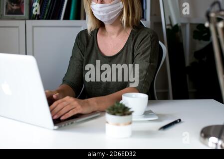 Woman working on her laptop with blank copy space screen. Mock up laptop with womans hands.Back view of business women hands using laptop.Home office Stock Photo