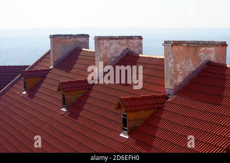 Red brick chimney on the roof of the house. Stock Photo