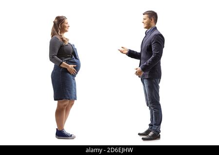 Full length profile shot of a pregnant woman listening to a man talking isolated on white background Stock Photo
