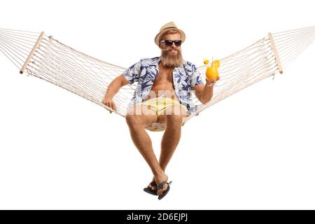 Young bearded man with hat and sunglasses sitting on a hammock swing with a cocktail isolated on white background Stock Photo